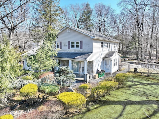 view of front of property with a gate, a shingled roof, a front lawn, and fence