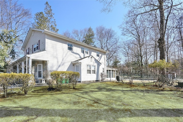 rear view of house featuring a yard and fence