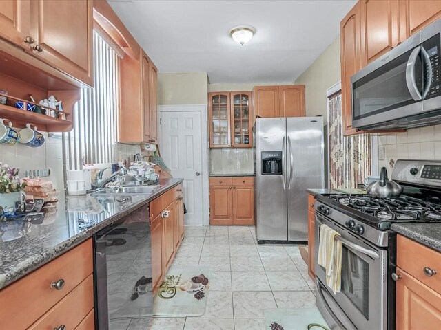 142-02 185th St, Springfield Gardens, NY 11413 - kitchen with tasteful backsplash, glass insert cabinets, dark stone countertops, appliances with stainless steel finishes, and a sink