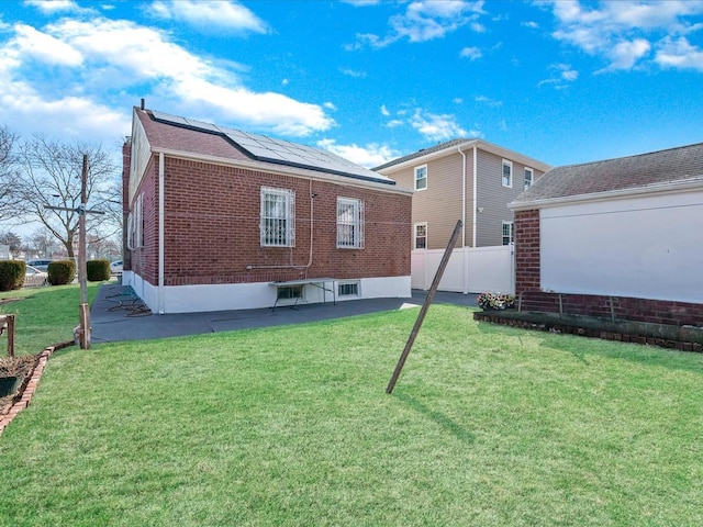 142-02 185th St, Springfield Gardens, NY 11413 - rear view of house featuring a yard, solar panels, and fence