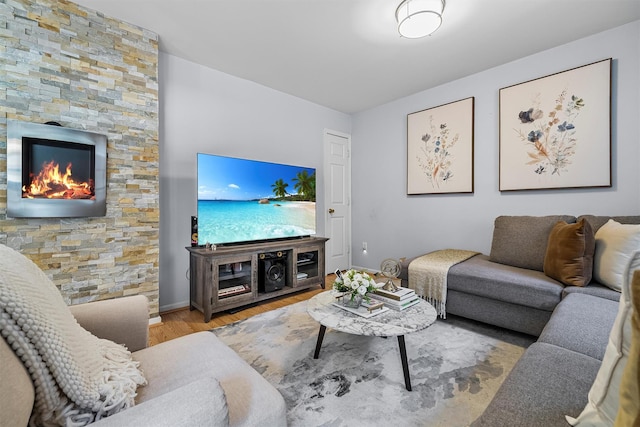 living area with a fireplace, wood finished floors, and baseboards