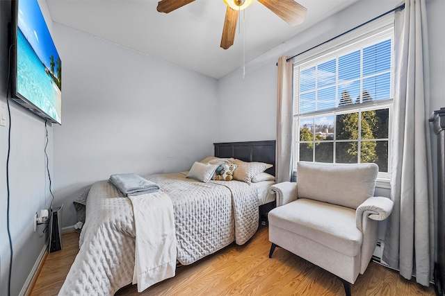 bedroom with baseboards, wood finished floors, and a ceiling fan