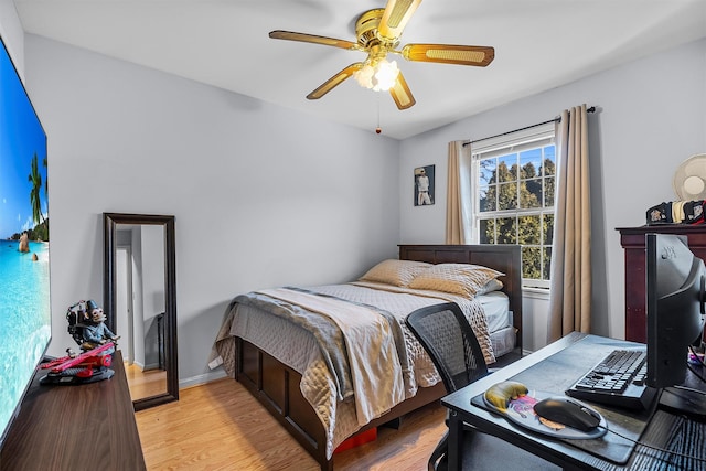 bedroom with light wood-type flooring, baseboards, and ceiling fan