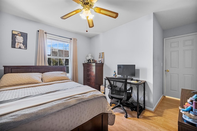 bedroom with ceiling fan, baseboards, and light wood-style flooring