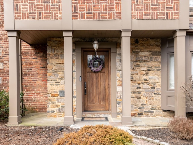 entrance to property featuring brick siding and stone siding