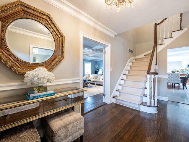 entryway with visible vents, dark wood-type flooring, crown molding, a chandelier, and stairway