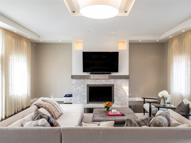 living room featuring a high end fireplace, recessed lighting, baseboards, and wood finished floors