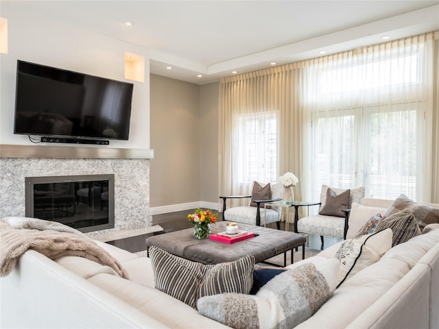 living area featuring recessed lighting, a fireplace, baseboards, and wood finished floors