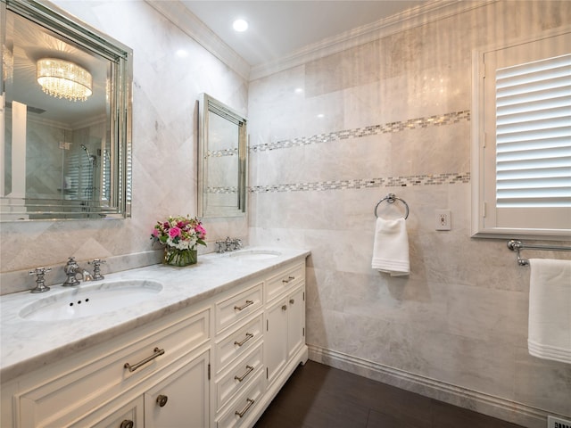 bathroom featuring double vanity, ornamental molding, tile walls, and a sink