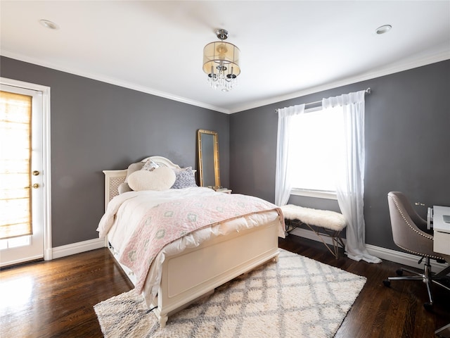 bedroom featuring an inviting chandelier, crown molding, wood finished floors, and baseboards