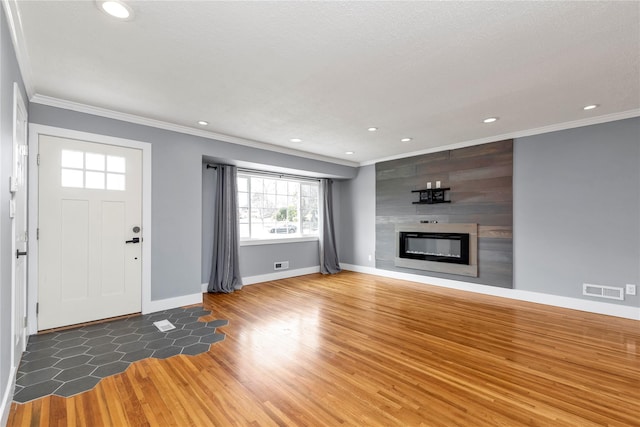 unfurnished living room featuring visible vents, ornamental molding, recessed lighting, a fireplace, and wood finished floors