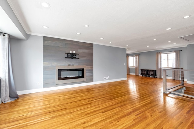 unfurnished living room featuring baseboards, light wood-type flooring, ornamental molding, recessed lighting, and a fireplace