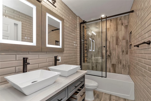 bathroom with tile walls, toilet, and a sink