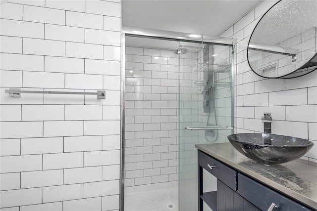 bathroom with vanity, a shower stall, tile walls, and decorative backsplash