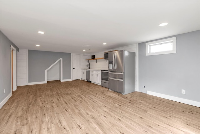 kitchen with open shelves, recessed lighting, appliances with stainless steel finishes, light wood finished floors, and decorative backsplash