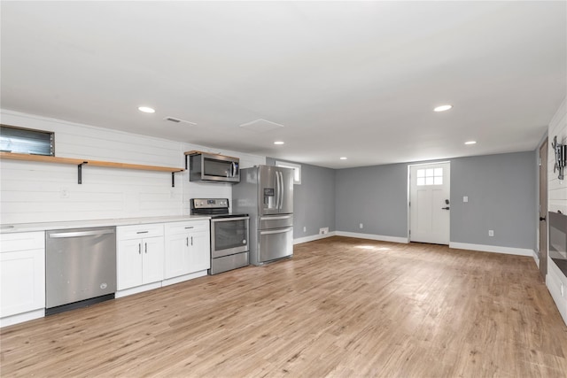 kitchen with light wood-style flooring, open shelves, stainless steel appliances, white cabinets, and light countertops