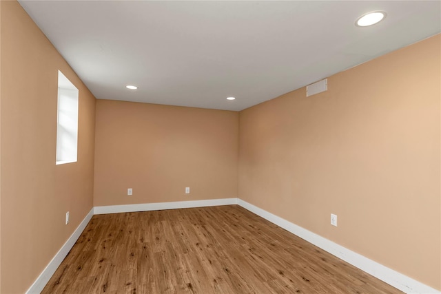 empty room with recessed lighting, baseboards, and wood finished floors