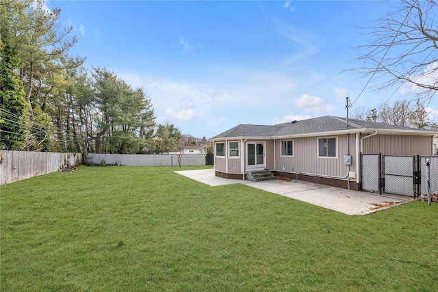 back of house with entry steps, a gate, a fenced backyard, and a lawn