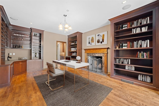 2 Camden Ct, Irvington, NY 10533 - home office with a fireplace with flush hearth, wood finished floors, bar, a chandelier, and built in shelves
