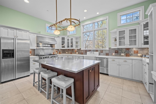 2 Camden Ct, Irvington, NY 10533 - kitchen with appliances with stainless steel finishes, wall chimney range hood, a chandelier, light countertops, and decorative backsplash