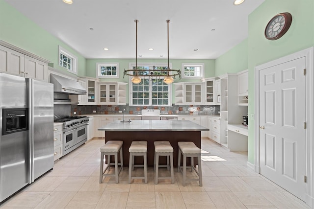 2 Camden Ct, Irvington, NY 10533 - kitchen featuring stainless steel appliances, exhaust hood, decorative backsplash, a center island, and a kitchen breakfast bar