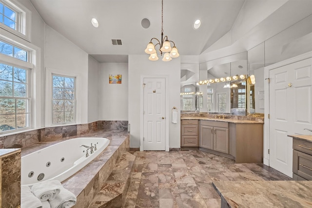 2 Camden Ct, Irvington, NY 10533 - bathroom with a chandelier, vaulted ceiling, vanity, a tub with jets, and recessed lighting