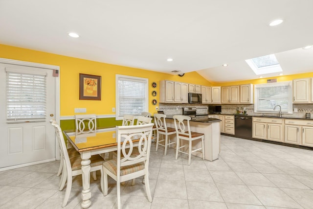 dining area featuring lofted ceiling with skylight, light tile patterned floors, and recessed lighting