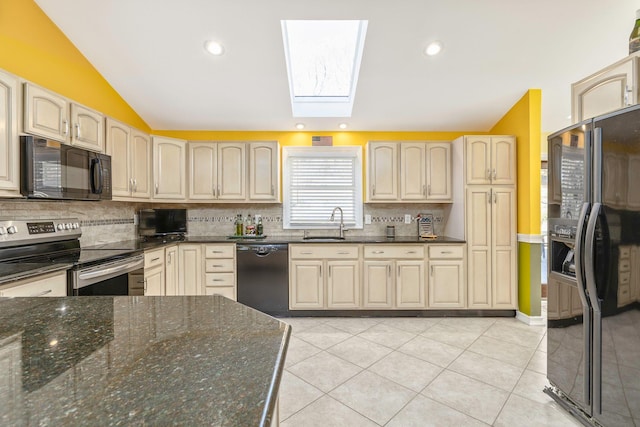 kitchen featuring light tile patterned flooring, a sink, decorative backsplash, black appliances, and lofted ceiling with skylight