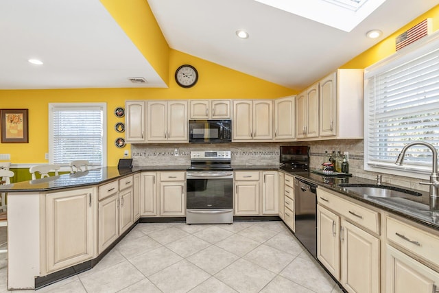 kitchen with visible vents, lofted ceiling with skylight, a peninsula, black appliances, and a sink