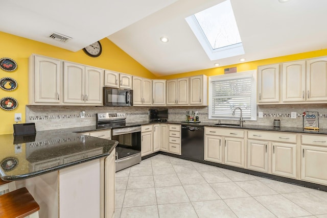 kitchen with visible vents, black appliances, a sink, dark stone counters, and vaulted ceiling with skylight