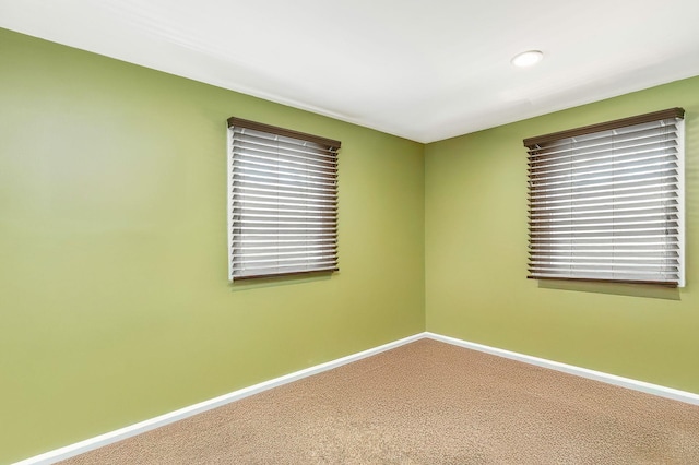 unfurnished room with baseboards and carpet