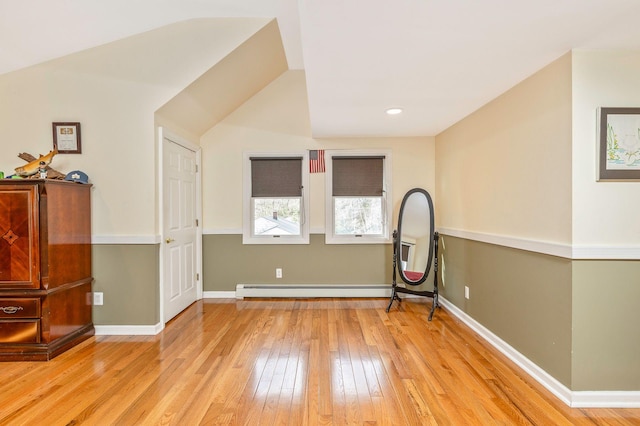 unfurnished room with a baseboard radiator, baseboards, and hardwood / wood-style floors