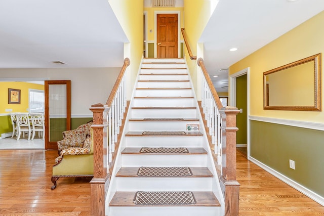 stairway with recessed lighting, baseboards, and wood finished floors