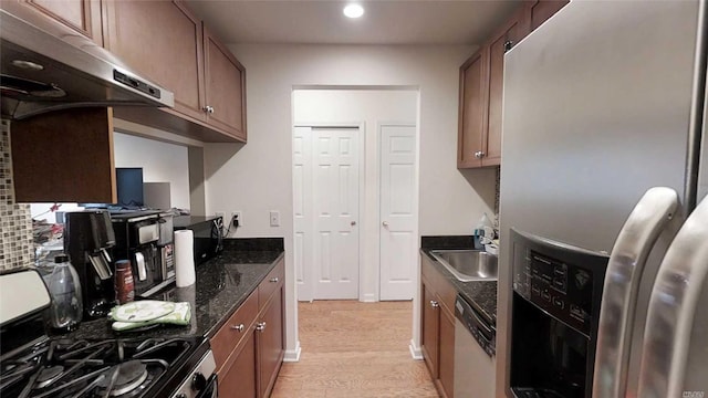 kitchen with a sink, under cabinet range hood, light wood-style floors, stainless steel fridge with ice dispenser, and dishwashing machine