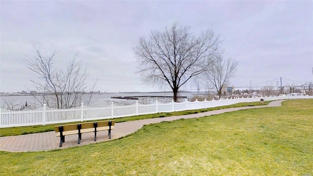 view of community with a lawn and fence