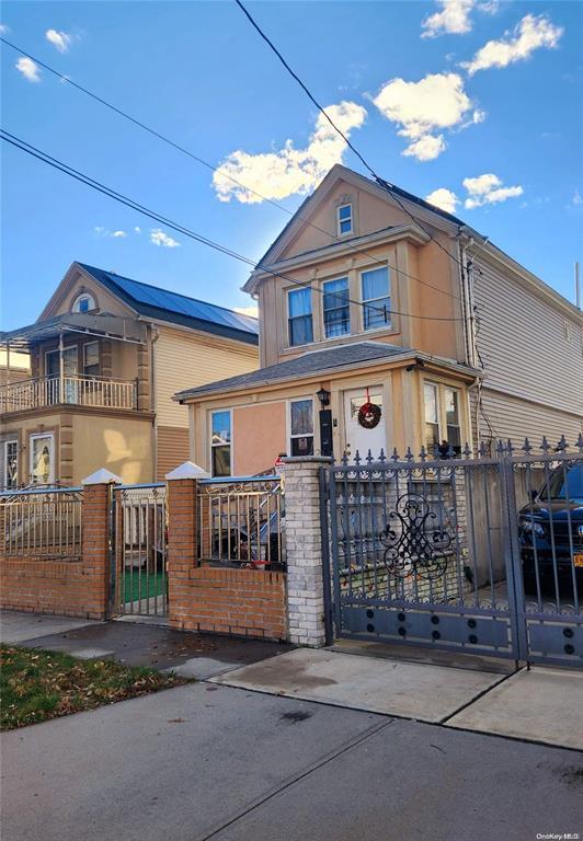 view of front of home with a fenced front yard and a gate