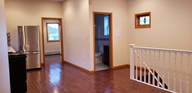 hall featuring baseboards, an upstairs landing, baseboard heating, and dark wood-type flooring