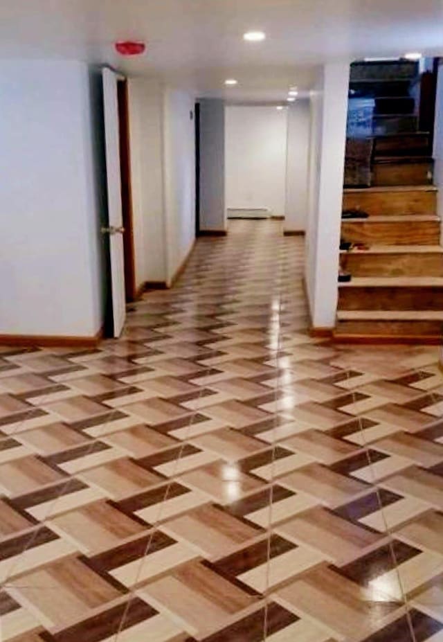 hallway featuring recessed lighting, a baseboard heating unit, and baseboards