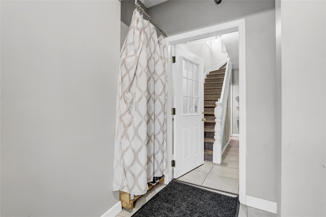 corridor featuring stairway and baseboards