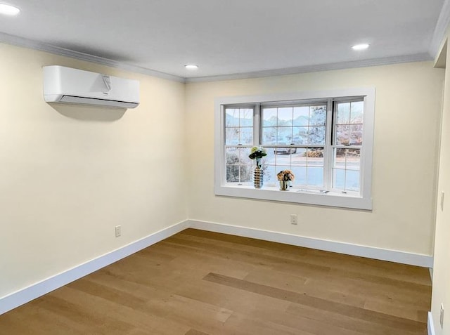 unfurnished room with baseboards, wood finished floors, ornamental molding, and a wall mounted AC