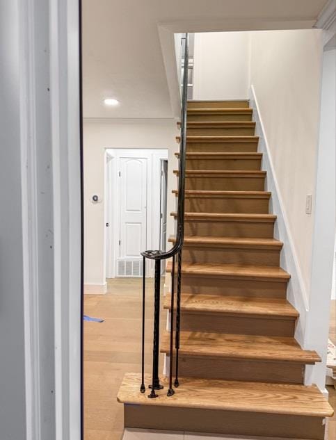 stairs with recessed lighting, wood finished floors, and visible vents