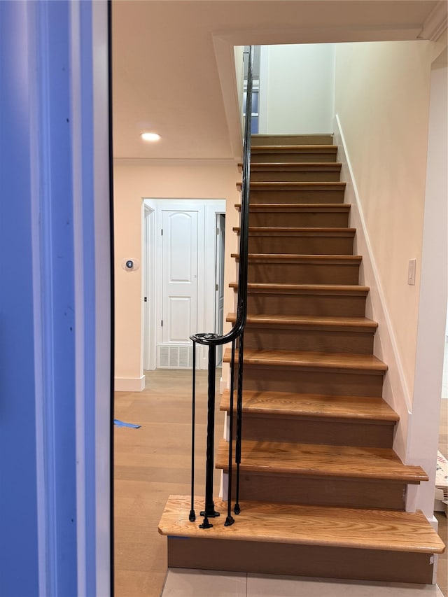 stairs with recessed lighting, wood finished floors, visible vents, and baseboards