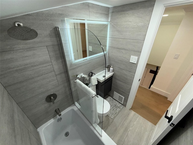 bathroom with visible vents, washtub / shower combination, vanity, and wood finished floors