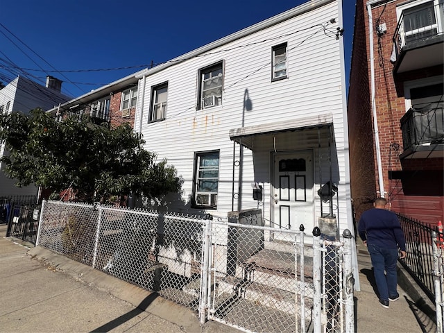 townhome / multi-family property with cooling unit and a fenced front yard