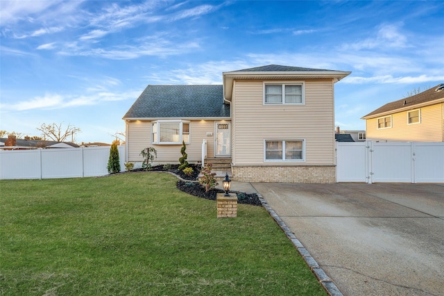 exterior space with a gate, fence, a front yard, a shingled roof, and brick siding