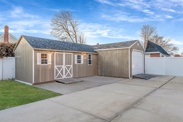 view of outdoor structure featuring an outbuilding and fence