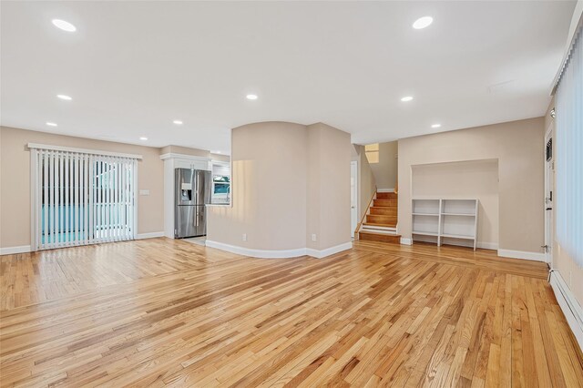 unfurnished living room featuring recessed lighting, stairway, light wood-style flooring, and baseboards