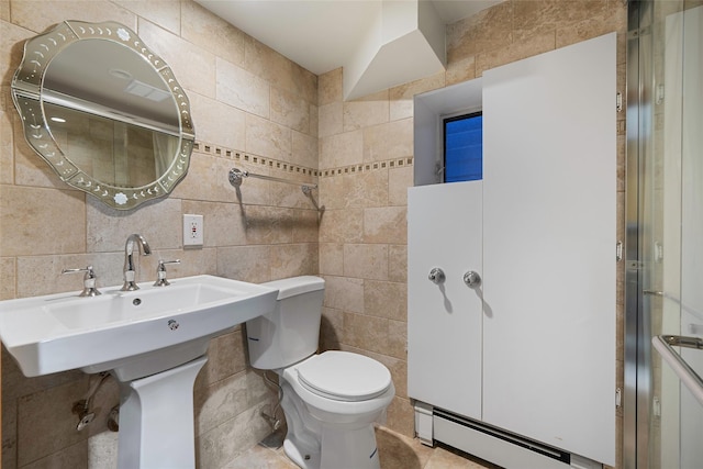 bathroom featuring an enclosed shower, a baseboard heating unit, toilet, and tile walls