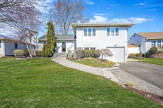 tri-level home featuring driveway, a front lawn, and a garage