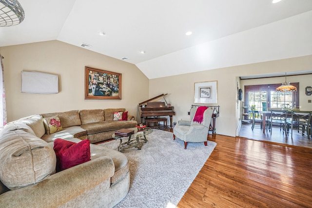 living area featuring visible vents, recessed lighting, wood finished floors, and vaulted ceiling